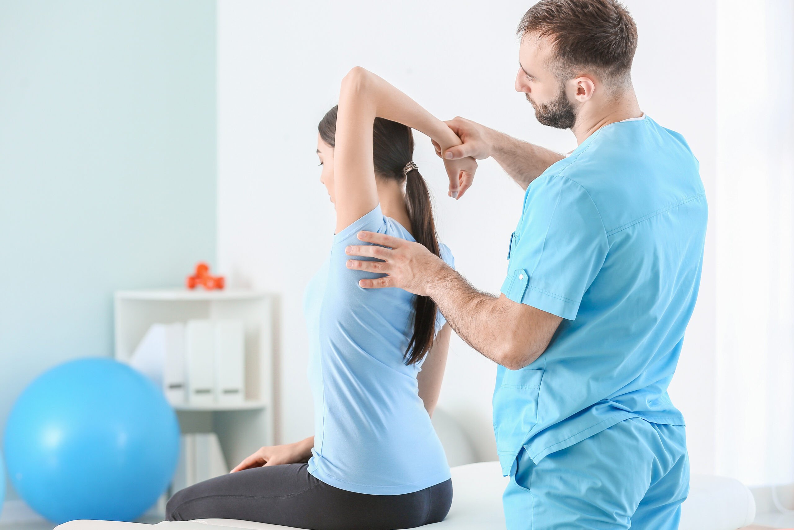 Physiotherapist working with female patient in rehabilitation center