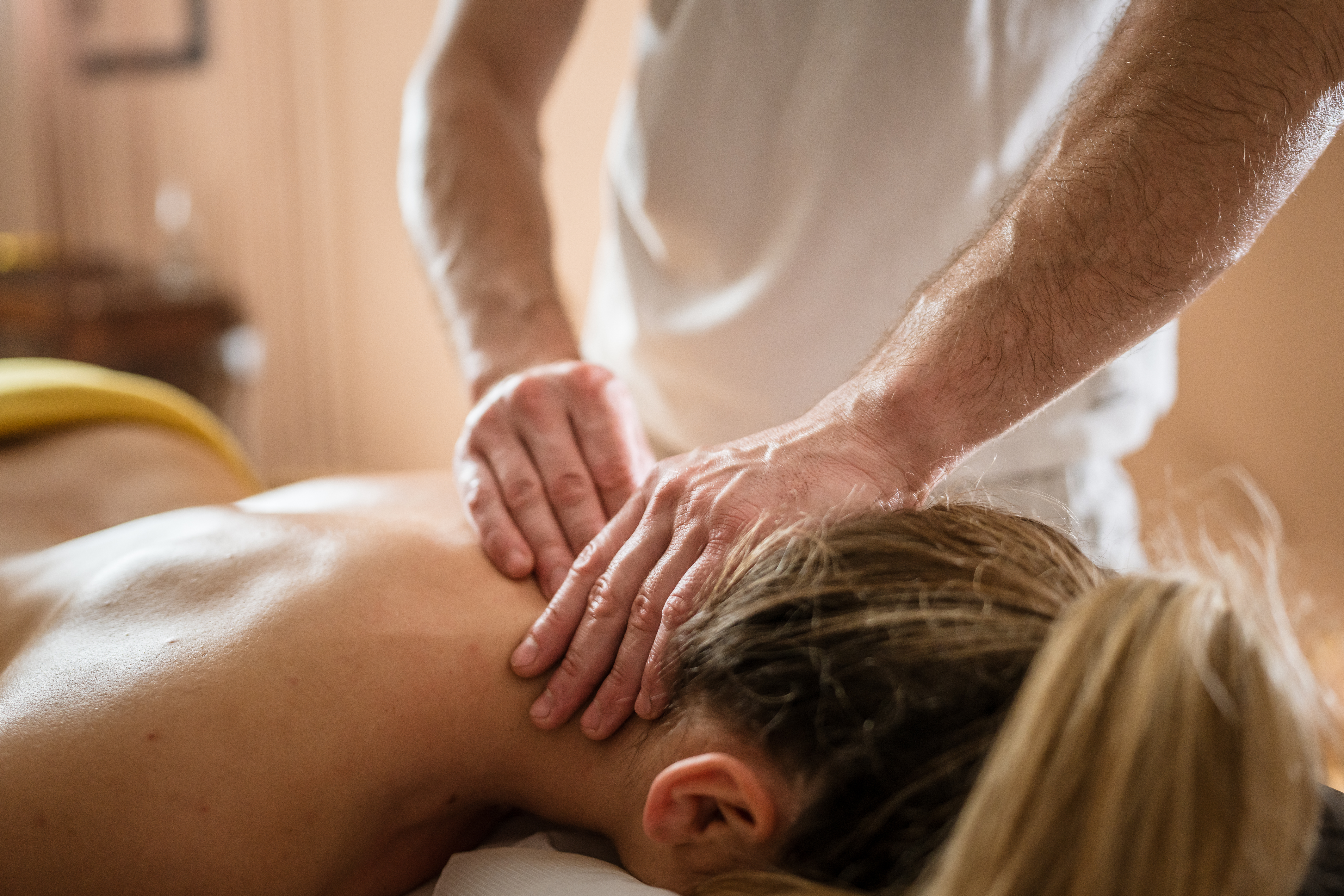 unknown woman enjoy neck massage at beauty spa male therapist